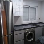 En este caso las puertas son en gris con un acabado un poco rugoso y encimera de granito de importación, dando luminosidad a la cocina con la vitrina en color blanco y dibujo al tono de la puerta